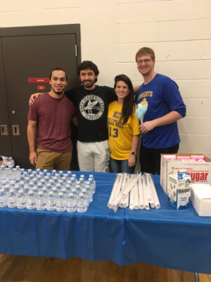 students behind a table serving concessions
