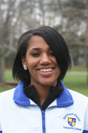 close up picture of Norelia Figueroa, she has a dark skin tone and short black hair and is wearing an athletic jacket
