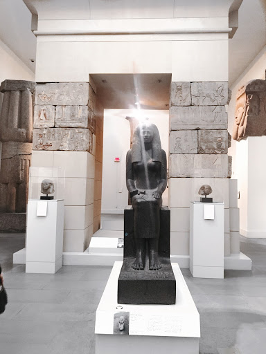 black statue of a pharaoh in a museum  