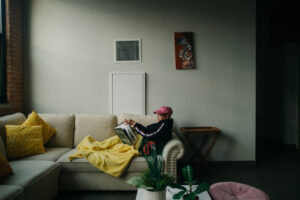 Josselyn Fernandez reading on her couch in her apartment