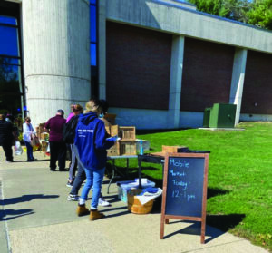 People look at the food available at the Mobile Market on the Haverhill campus
