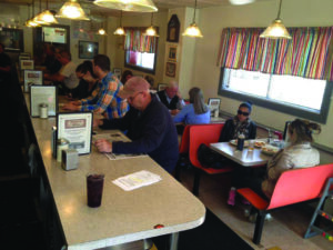 Customers sit at the counter at Mark's Deli.