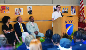 A student stands at a podium to make a speech at convocation in the Tech Center. 