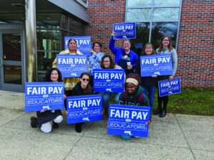 Faculty members hold signs calling for Fair Pay for Educators