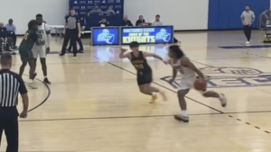 A Knights basketball player dribbling a baskettball passed a defender