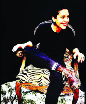 A woman in a chair performs in a play.