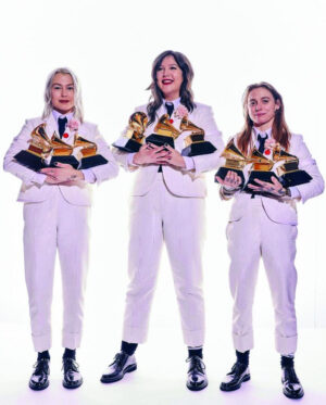 Three women standing holding Grammy award trophies