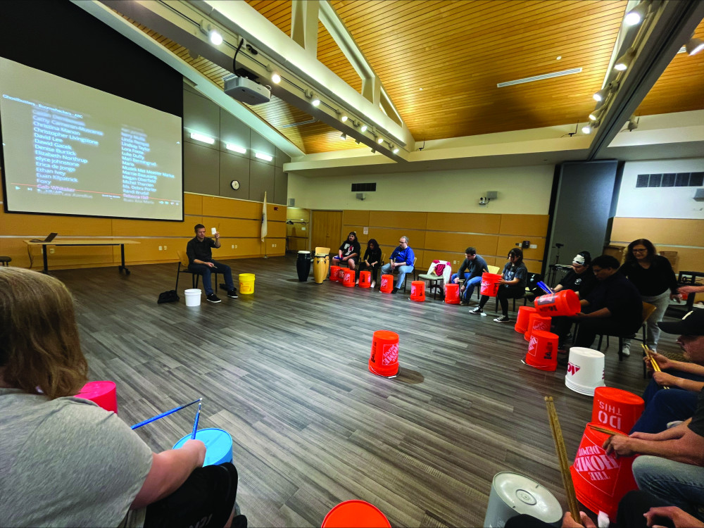 A group of students playing music with buckets