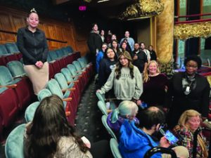 Students standing in the seats of a theater