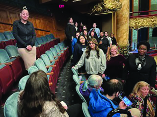 Students standing in the seats of a theater