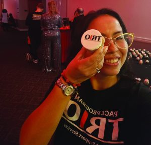 Female student takes a selfie holding a TRIO cupcake