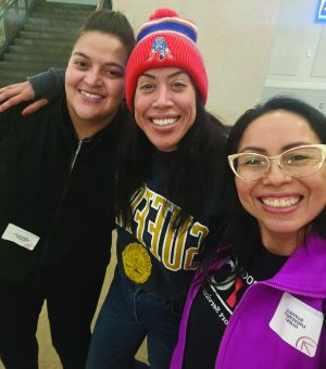 Three students smile and take a selfie together