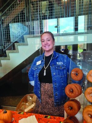 A woman standing in front of a table with pumpkins on it.