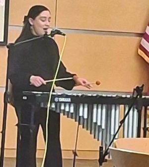 A woman sings and plays a xylophone