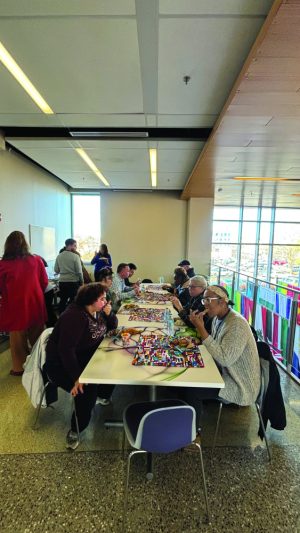 People sit at a long table eating food.