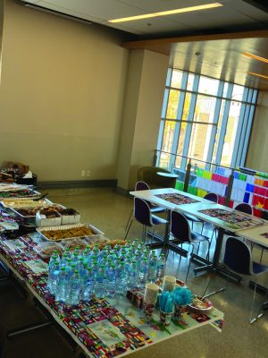 Tables with water and food with international flags behind them.