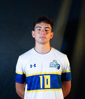 A man wearing an NECC Knights soccer jersey looks at the camera.