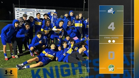 A group of male soccer players pose for group photo as they celebrate.