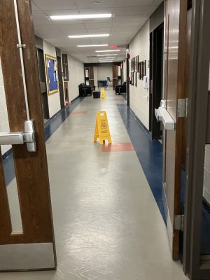 Buckets in the hallway and a caution wet surface sign in Spurk C Building on NECC's Haverhill Campus.