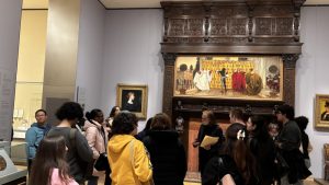 A group of people look at a painting in the Museum of Fine Arts in Boston. 