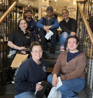 A group of students and NECC staff pose for a photo at a chocolate factory.