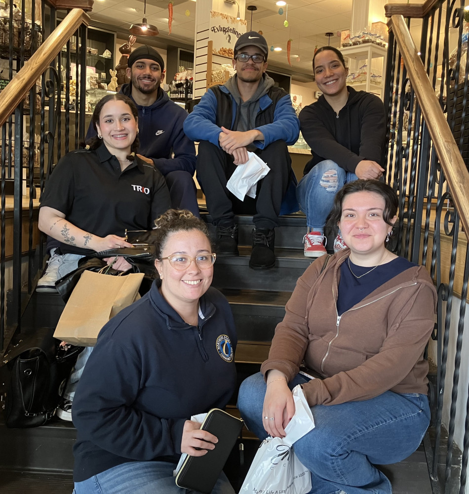 A group of students and NECC staff pose for a photo at a chocolate factory.