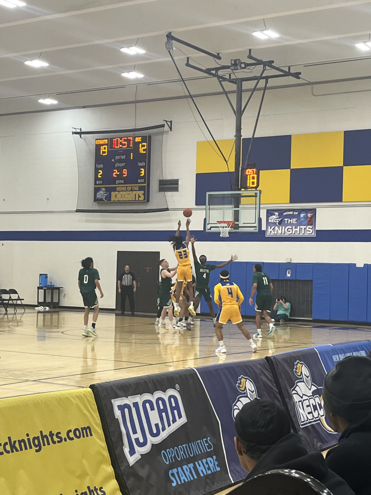 A basketball player jumps up to the basket with the ball.