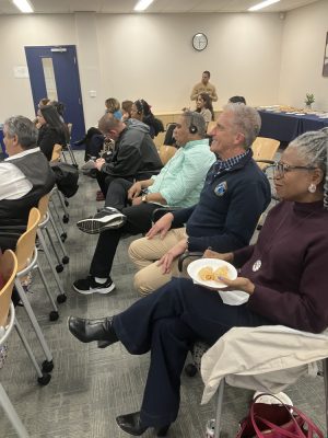 NECC President Lane Glenn is smiling and watching the performance along with a group of people
